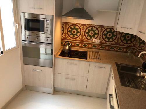 a kitchen with a stove and a microwave at White Loft Alicante in Alicante