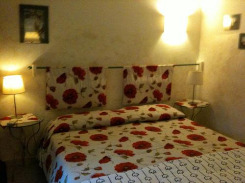 a bedroom with a bed with a floral bedspread and two lamps at La Casa di Ulisse B&B in Quercianella