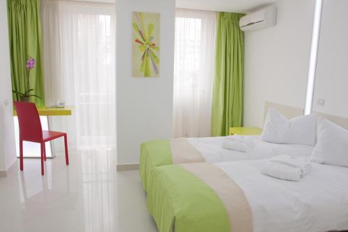 une chambre d'hôtel avec un lit et un fauteuil rouge dans l'établissement Christina Hotel, à Bucarest