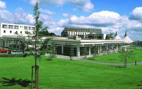 un gran edificio con un césped verde delante de él en Hotel Rennsteig en Masserberg