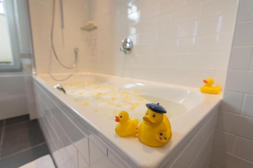 two rubber ducks sitting on top of a bath tub at Boutique-Hotel Garni Bellevue Davos Wiesen in Wiesen