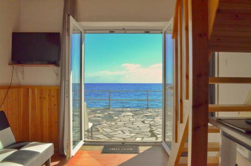 a view of the ocean from a room with a sliding glass door at Myrtos Harmony Apartments in Myrtos