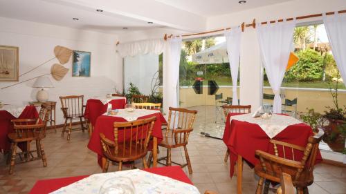 ein Restaurant mit Tischen und Stühlen mit rotem Tischtuch in der Unterkunft Bagu Villa de Mar in Punta del Este