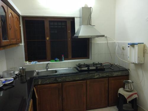 a kitchen with a sink and a stove at Edasseriathu Homestays Tiruvalla in Tiruvalla