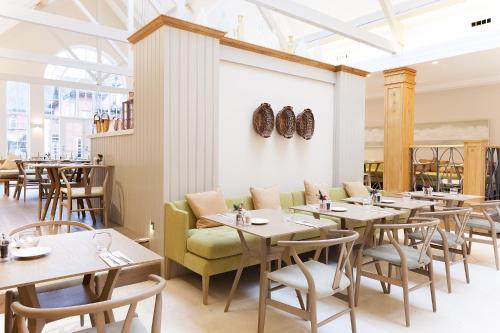 a dining room with tables and a couch and chairs at Champneys Forest Mere in Liphook