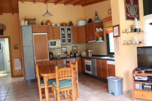 een keuken met een tafel en stoelen en een televisie bij Chalet privado playa in Noya