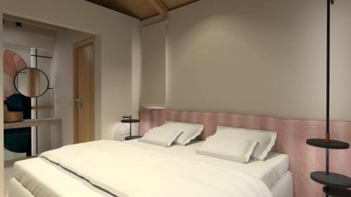 a bedroom with a white bed with two pillows at Artblue Villas in Tsoukaladhes