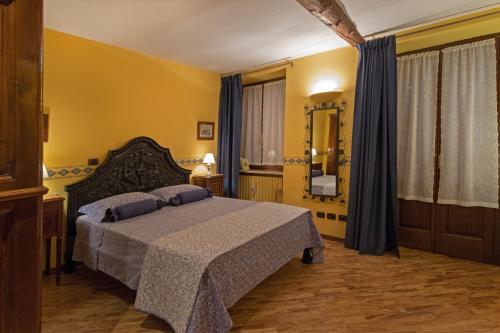 Schlafzimmer mit einem Bett und einem Spiegel in der Unterkunft B&B Contrada dei Giardini in Cuneo