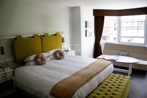 a bedroom with a large bed and a table and a window at The Globe in Exeter