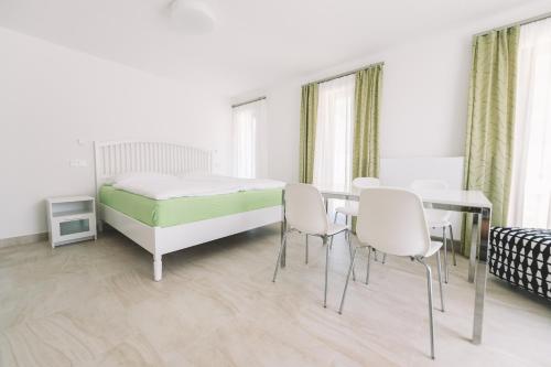 1 dormitorio con 1 cama, mesa y sillas en Apartmány v rodinném domě en Hluboká nad Vltavou
