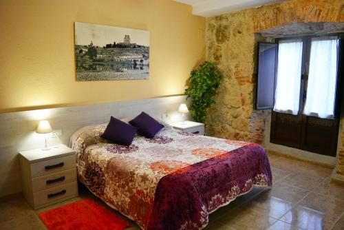 een slaapkamer met een bed en twee nachtkastjes en een raam bij Apartamento Palacio Antigua Audiencia in Ciudad-Rodrigo