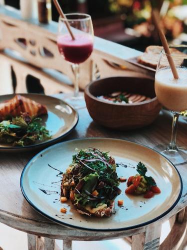 een tafel met borden eten en glazen drank bij B Saya Villas in Ubud