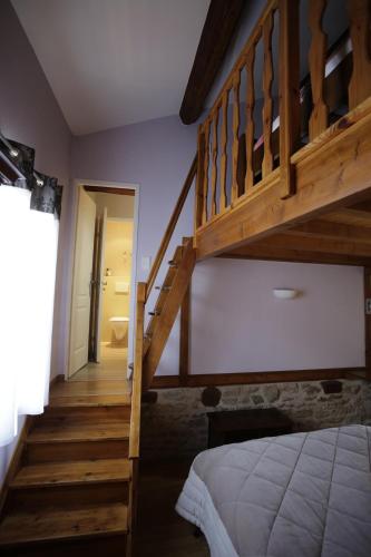 a bedroom with a wooden staircase with a bed and a stair case at Carpe Diem in Soucieu-en-Jarrest