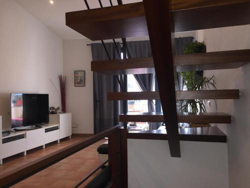 カダケスにあるCal Montaner Casa 3 habitaciones 3 baños y Garajeのリビングルーム(らせん階段、テレビ付)