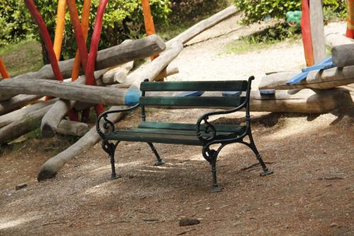 a green park bench sitting in a playground at Studio Apartments Andrijana in Mlini