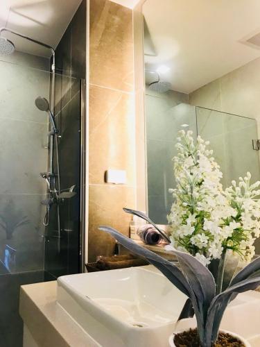 a bathroom with a shower and a sink with a plant at Astra Suites Central in Chiang Mai