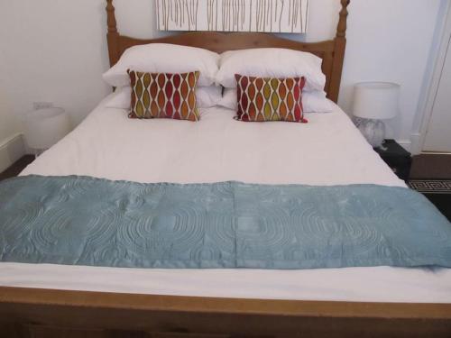 a bed with a blue blanket on top of it at The Beatnik, Victorian townhouse apartment with parking in Plymouth