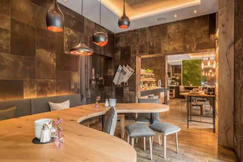 a restaurant with a large wooden table and chairs at Bavaria Boutique Hotel in Munich