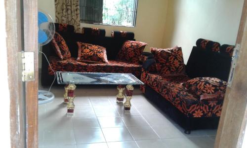 a living room with two chairs and a table at JJ & JE Family House in Dar es Salaam