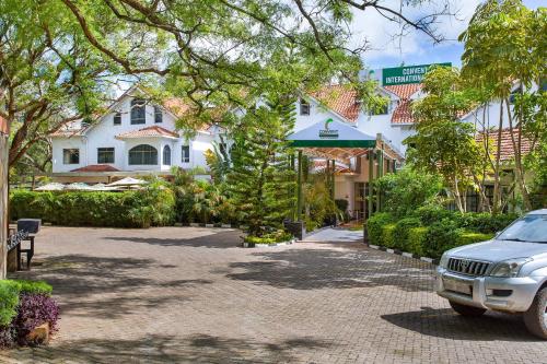 a car parked in a driveway in front of a building at Convent International Hotel- Nairobi in Nairobi