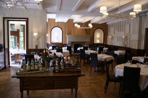 une salle à manger avec des tables, des chaises et une cheminée dans l'établissement Logis Hotel Du Chateau, à Combourg