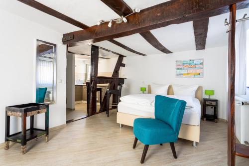 een slaapkamer met een bed en een blauwe stoel bij Hotel Werner in Mornshausen