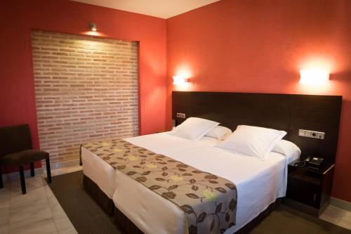 a bedroom with a large bed and a red wall at Pintor El Greco in Toledo