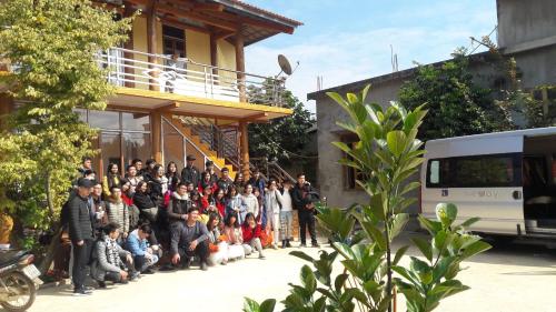 a large group of people standing outside of a building at Datani Mộc Châu Homestay in Làng Môn