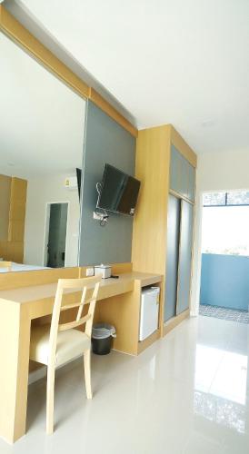 a room with a desk with a chair and a television at APA-TREE Boutique Hotel in Natai Beach