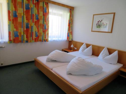 ein Hotelzimmer mit 2 Betten und weißen Kissen in der Unterkunft Gästehaus Post in Prägraten