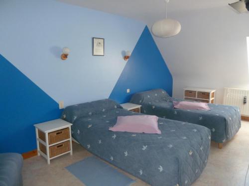 2 letti in una camera con pareti blu di Les Pres-Salés a Courtils