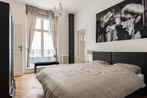 a bedroom with a bed with a poster on the wall at Roaring 20's Apartment Meir in Antwerp