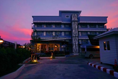 a large building with a sunset in the background at APA-TREE Boutique Hotel in Natai Beach