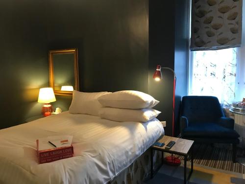 1 dormitorio con 1 cama con espejo y silla en Regency Rooms, en Littlehampton