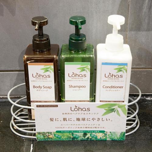 a group of three bottles of soap on a rack at Super Hotel Kushiro-Ekimae in Kushiro