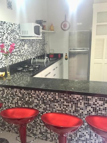 una cocina con 2 taburetes rojos y una barra en Melhor de Ipanema, en Río de Janeiro