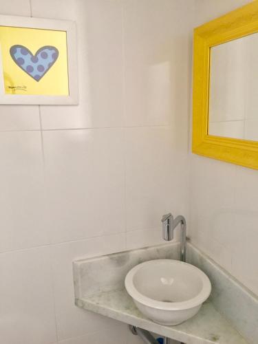 Baño blanco con lavabo y espejo en Melhor de Ipanema, en Río de Janeiro