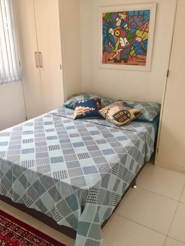 a bedroom with a bed with a blue comforter at Melhor de Ipanema in Rio de Janeiro