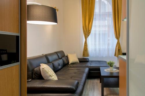 Walkway Apartment Deluxe في بودابست: غرفة معيشة مع أريكة جلدية وطاولة