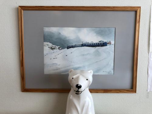 a picture of a polar bear in front of a painting at Hotel Angmagssalik in Tasiilaq