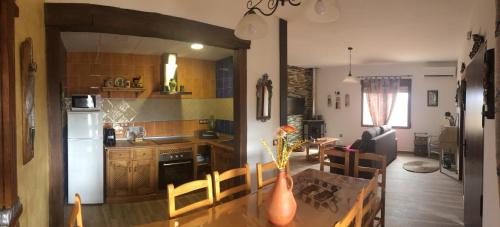 a kitchen and living room with a table and a dining room at El Retiro de Cervantes in Ossa de Montiel