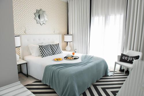 a bedroom with a bed with a tray of food on it at Hotel Cristal Marinha in Marinha Grande