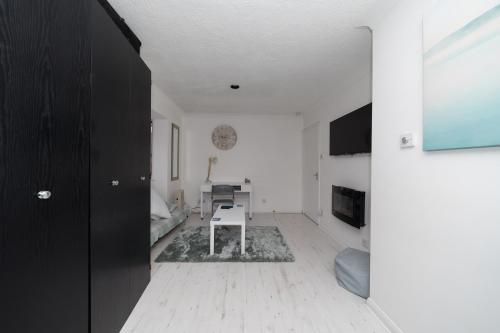 a white living room with a table in a room at Hullidays - Trinity Studio Apt. in Hull