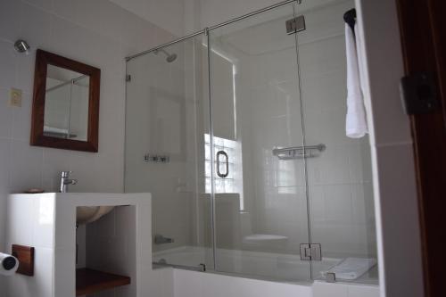 a glass shower in a bathroom with a sink at Casa Meba Hotel Boutique in Tampico