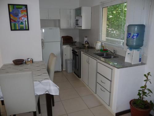 a kitchen with a table and a white refrigerator at Rincón Del Golf in Pinamar
