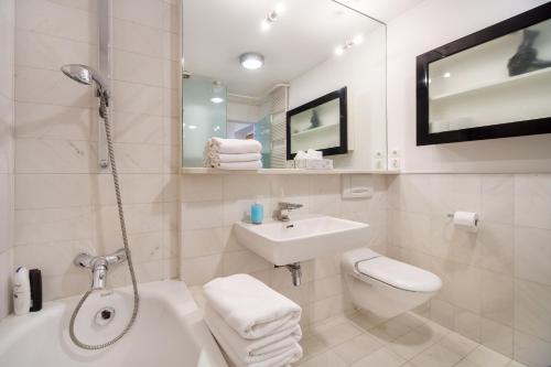 Baño blanco con lavabo y aseo en Apartment Fine Dalmatinova, en Liubliana