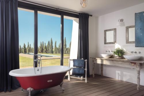 ヘレス・デ・ラ・フロンテーラにあるHACIENDA LAS MESAS - Luxury Villa Jerezのバスルーム(バスタブ付)、大きな窓が備わります。