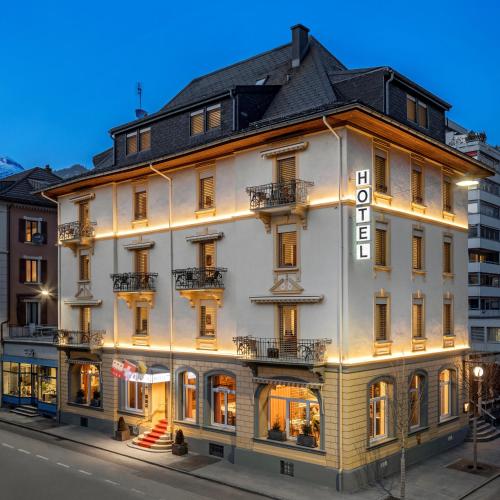 a large white building with lights on it at Hotel Ambassador in Brig