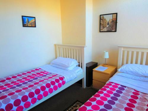 two beds sitting next to each other in a room at The Apothecary Guest House in Haworth