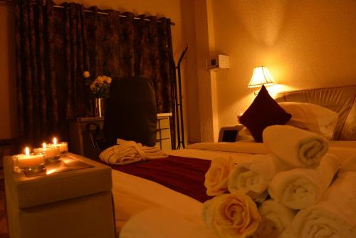 a hotel room with a bed with towels and candles at Eusbett Hotel in Sunyani